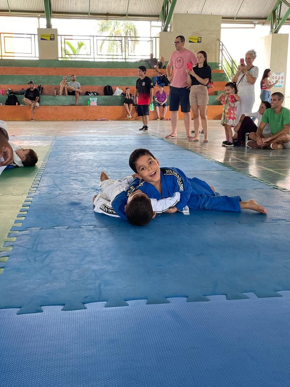 Crianças treinando judô no tatame do clube