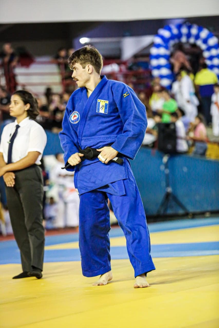 Atleta do clube de kimono azul entrando no tatame
